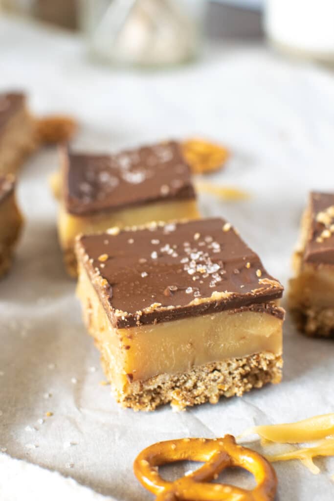 Chocolate caramel bars with a salted pretzel crust and a sprinkle of sea salt on top.