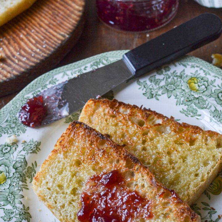 2 slices of toasted English muffin loaf on a green transfer ware plate