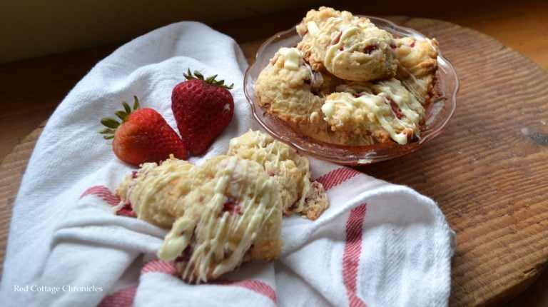 Strawberry shortcake cookies on a white napkin with red stripes on it.