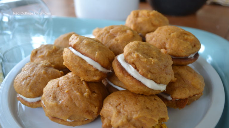 Mini pumpkin whoopie pies piled on a plate.