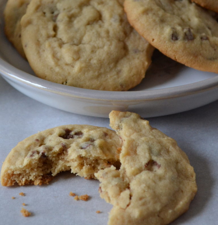 A plate of peanut butter chocolate chunk cookies with one broken in half.