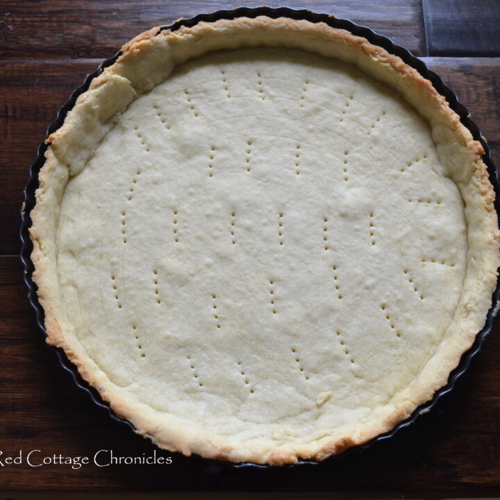 Blind baked sweet pastry dough in a fluted tart pan.