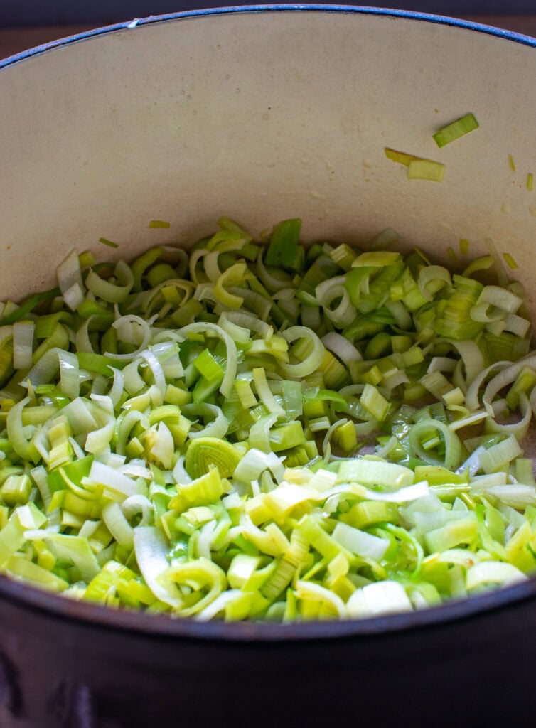 Chopped leeks in a soup pot with melted butter and olive oil.