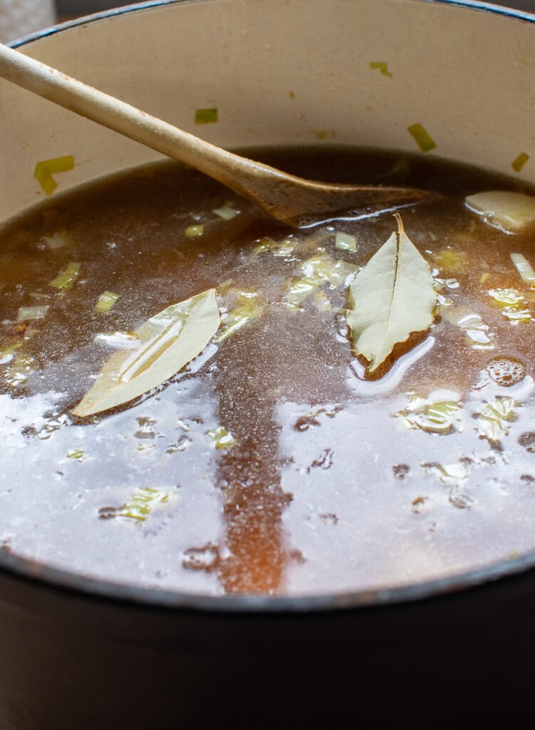 Ingredients for potato leek soup in a dutch oven on the stove top.