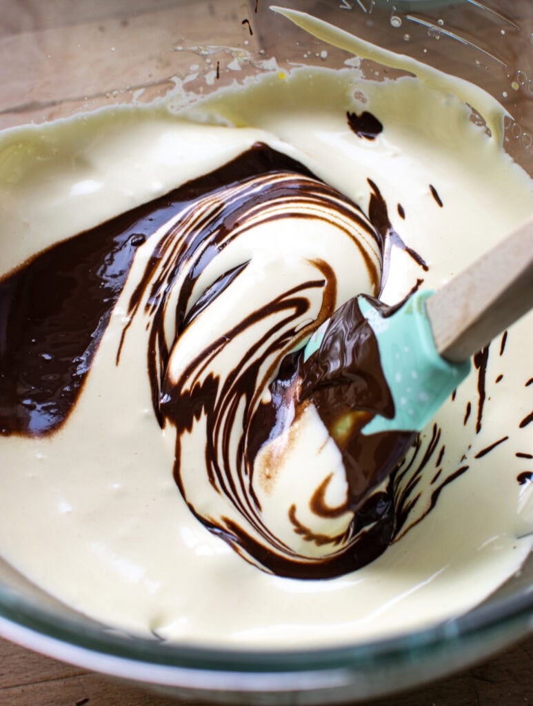 Melted chocolate being folded into a whipped egg and sugar mixture to make chocolate mousse.