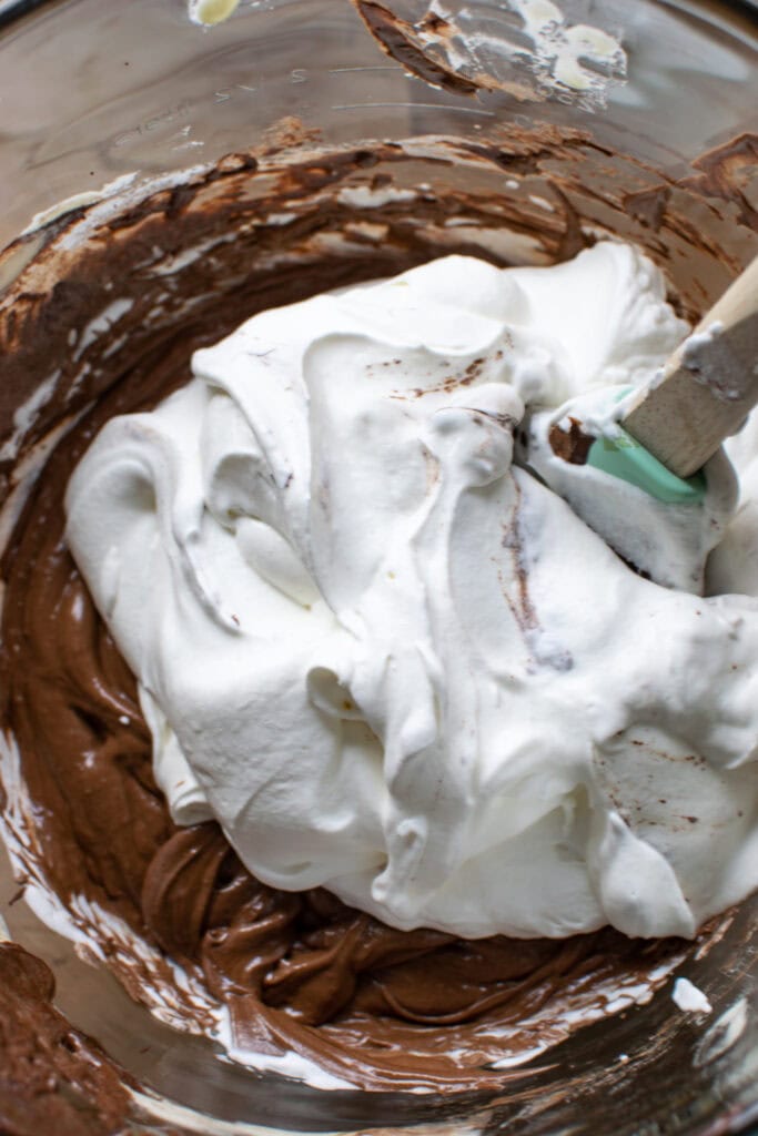 Fresh whipped cream on top of chocolate and egg mixture before folding in to make mousse.