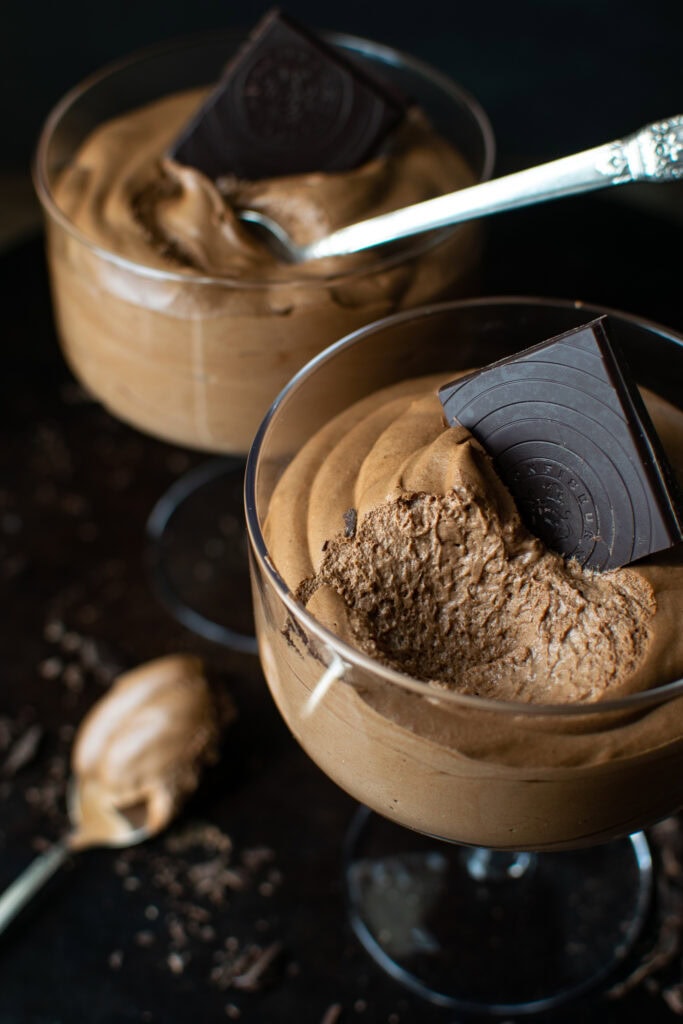 Chocolate Mousse in a dessert cup with a spoonful taken out to show the light, airy texture of the mousse.