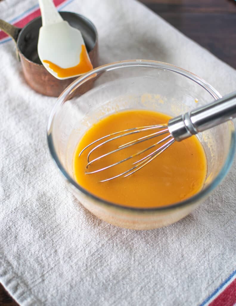 Butter and hot sauce being whisked together to make Buffalo Wing Sauce