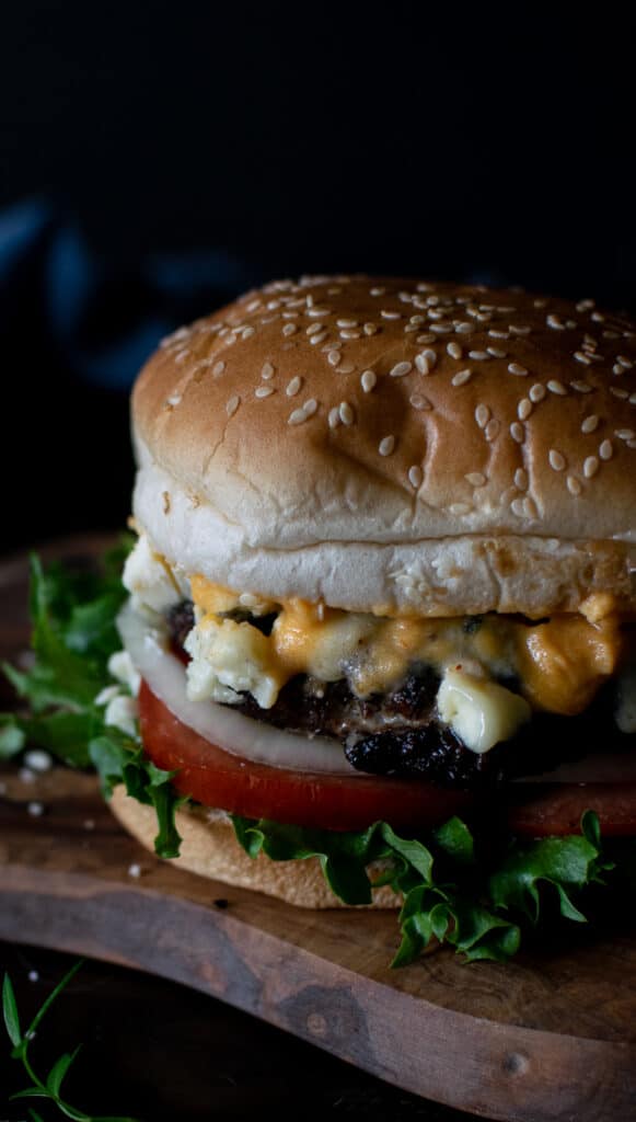 Close up of a hamburger with Buffalo sauce and blue cheese.