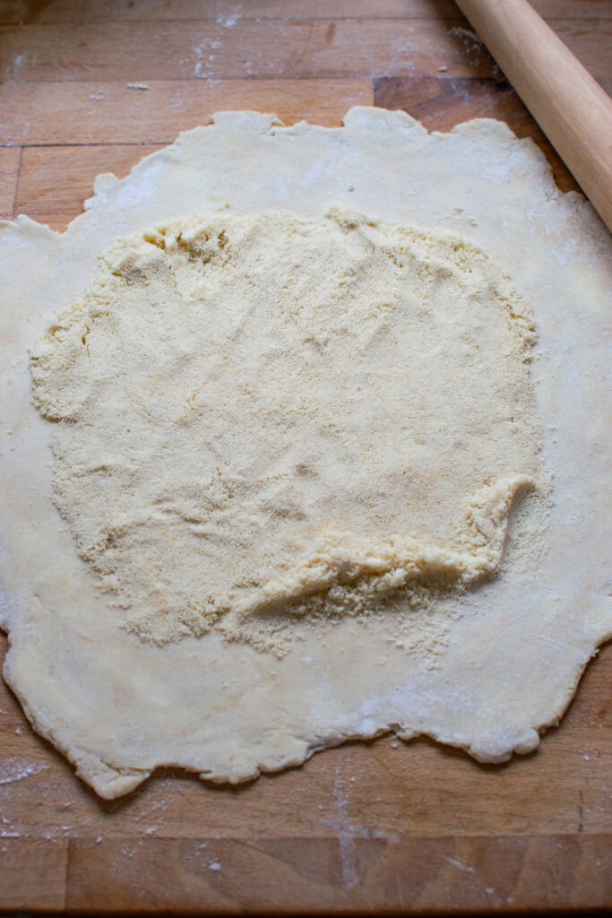 Pie crust that has been rolled out and topped with ground almonds.