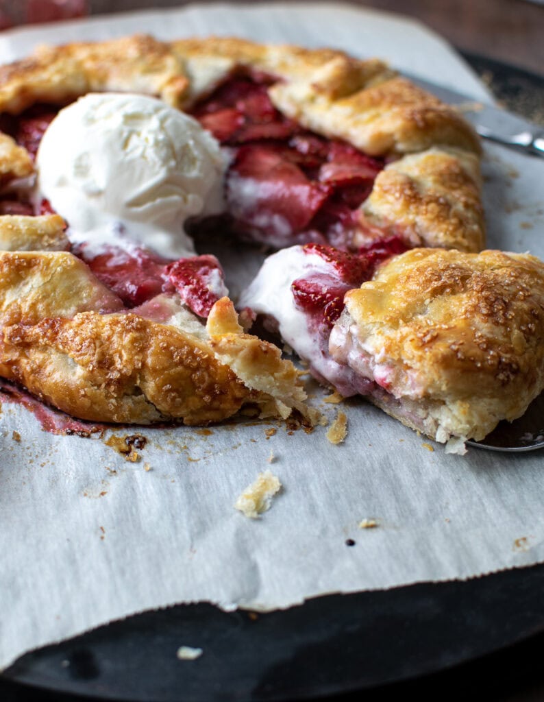 A galette made with strawberries and topped with a scoop of vanilla ice cream