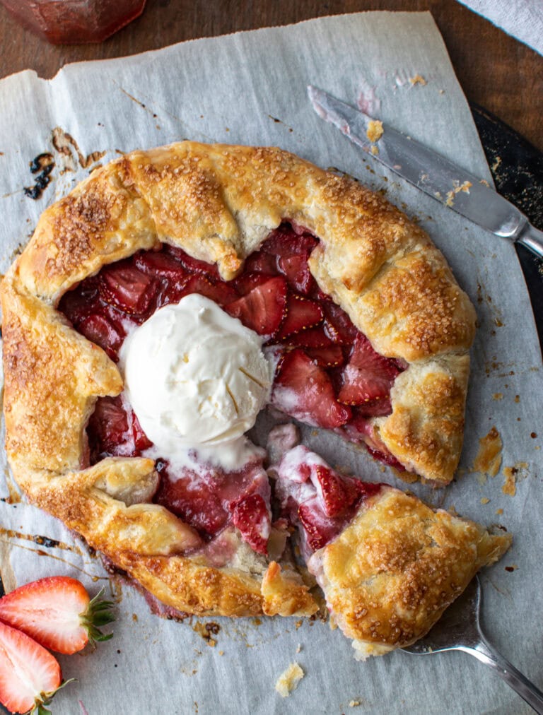 A strawberry galette topped with a scoop of ice cream.