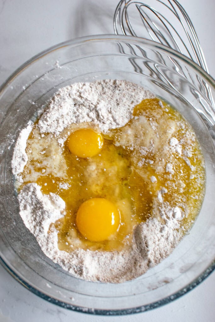 Eggs and melted butter added to a cake mix and brown sugar mixture in a mixing bowl.