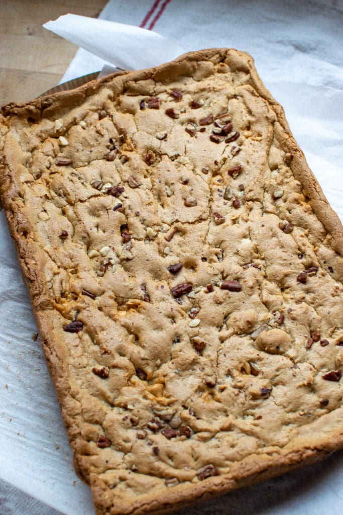 Blondie bars fresh out of the oven, on a piece of parchment paper.