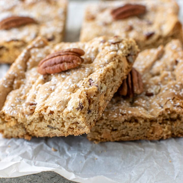 Pecan Blondie Bars on a sheet of parchment paper.