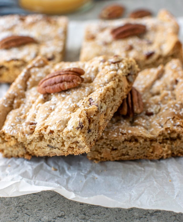 Pecan Blondie Bars on a sheet of parchment paper.