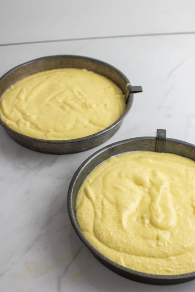 sponge cake batter divided between 2 eight inch round baking pans