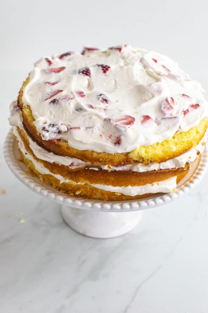 3 layers of sponge cake with whipped cream and strawberry mixture between each layer.