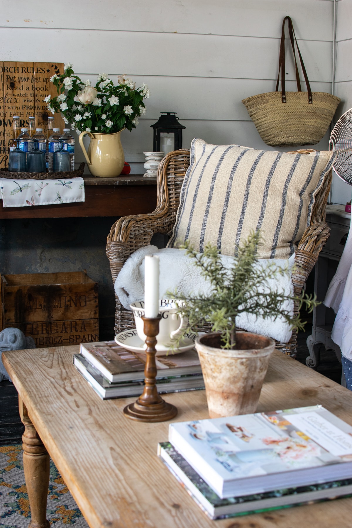 Wicker chair with a while and blue striped cushion in a summer screen porch.