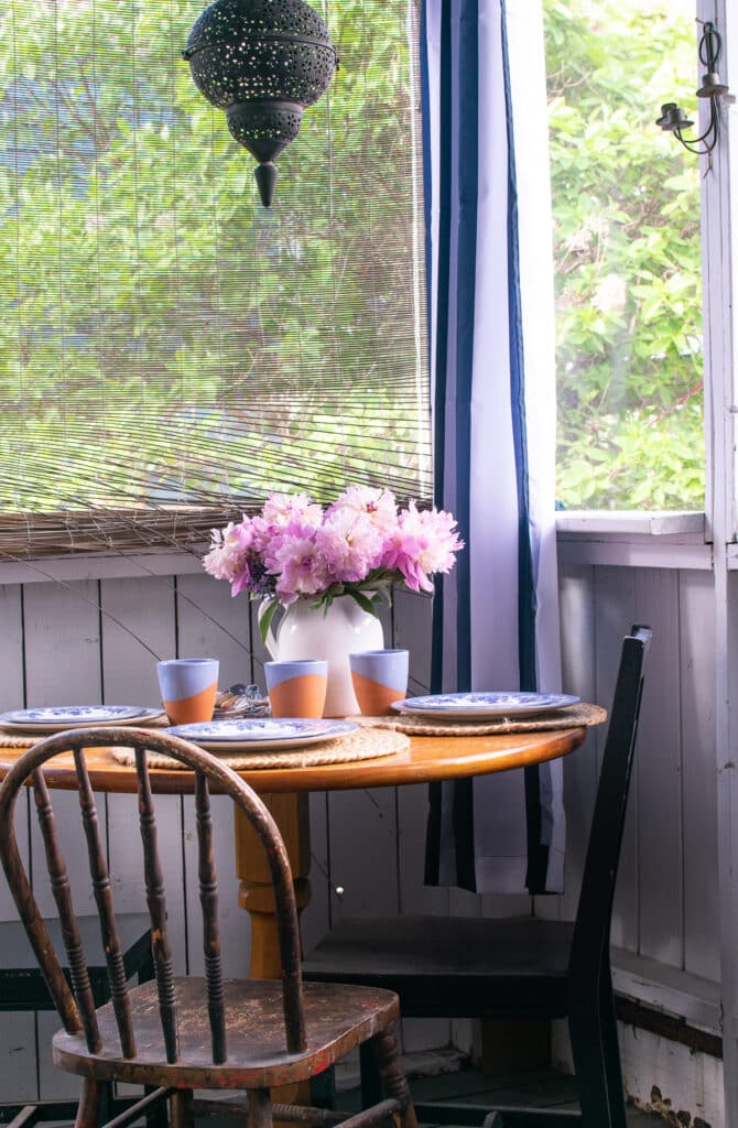 A far away look at a table set for dinner in a screen porch.