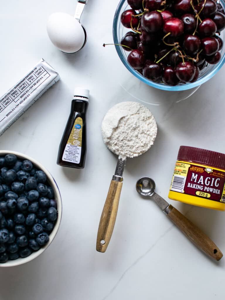 Overhead view of ingredients required to make blueberry cherry cobbler