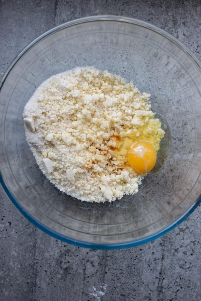 An egg and vanilla added to a flour butter mixture.