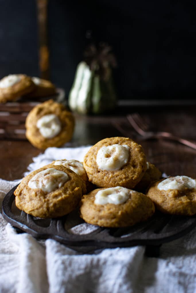 Pumpkin Cheesecake cookies stacked on a pumpkin trivet.