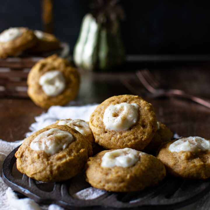 Pumpkin Cheesecake cookies stacked on a pumpkin trivet.