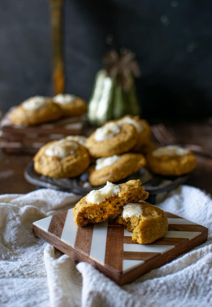 Pumpkin Cheesecake thumbprint cookies on a wood and marble coaster.