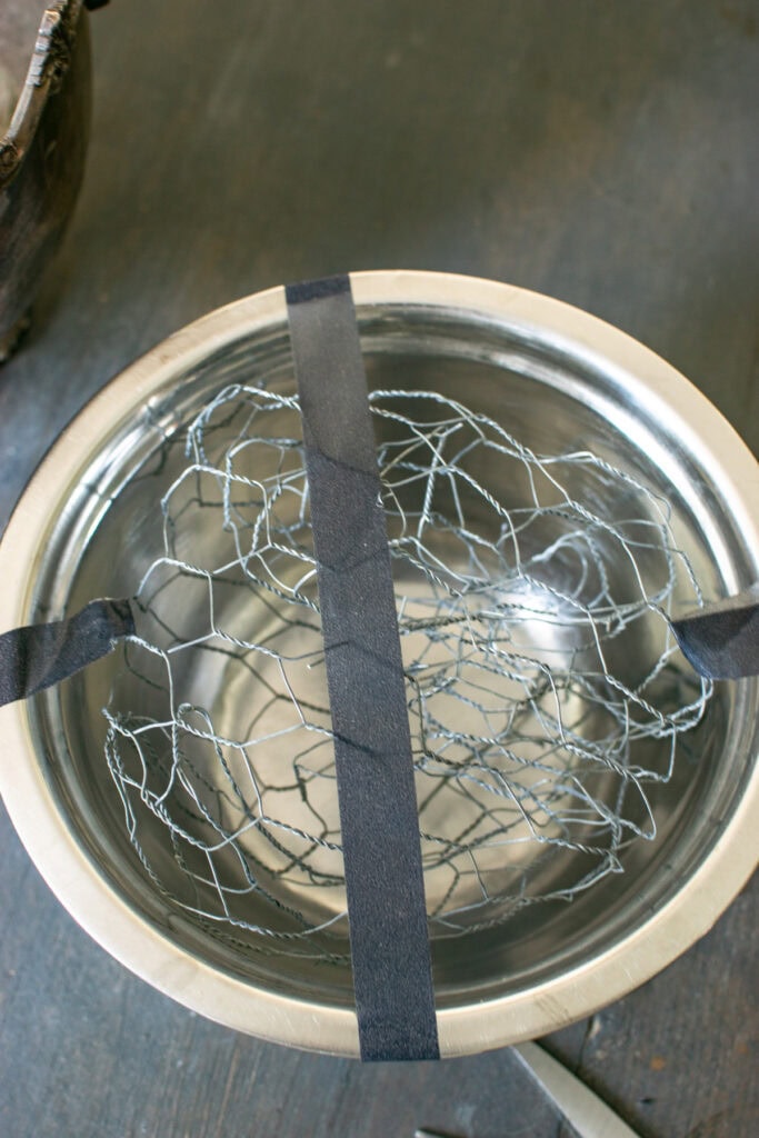 Chicken wire scrunched up in a bowl to hold flowers for a centrepiece.