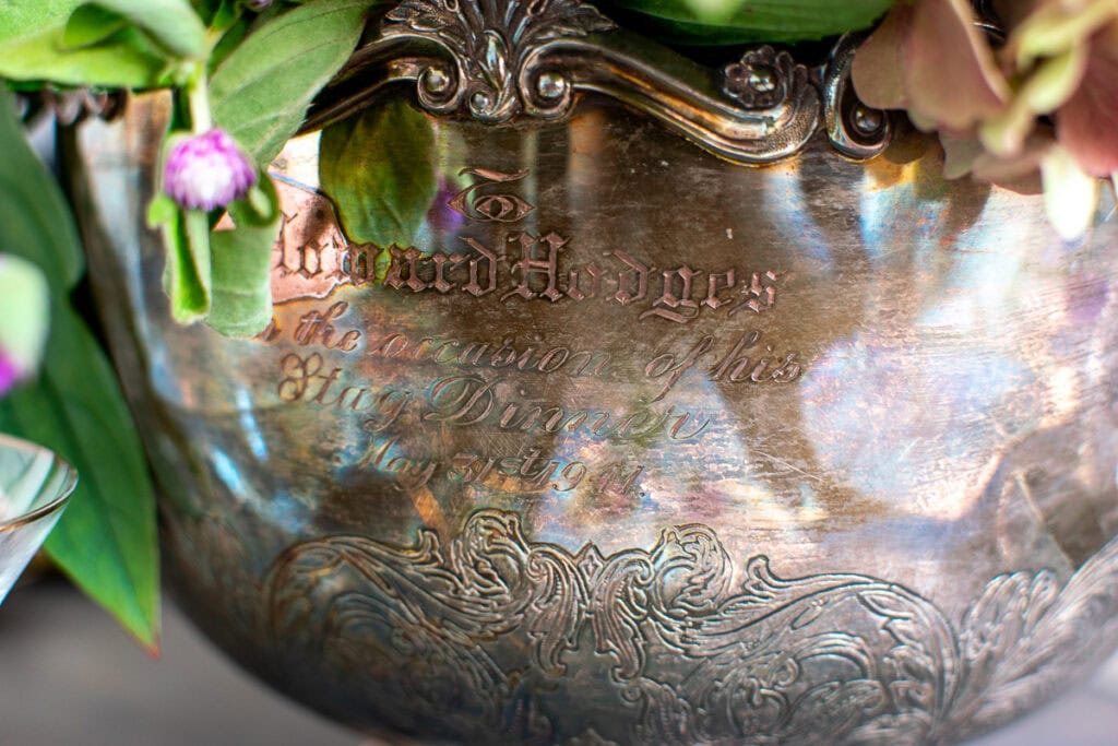 Silver-plate ice bucket used as a vase for a centrepiece.