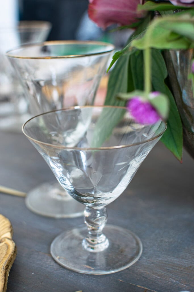 Close up photo of crystal wine and water glasses with a gold rim.