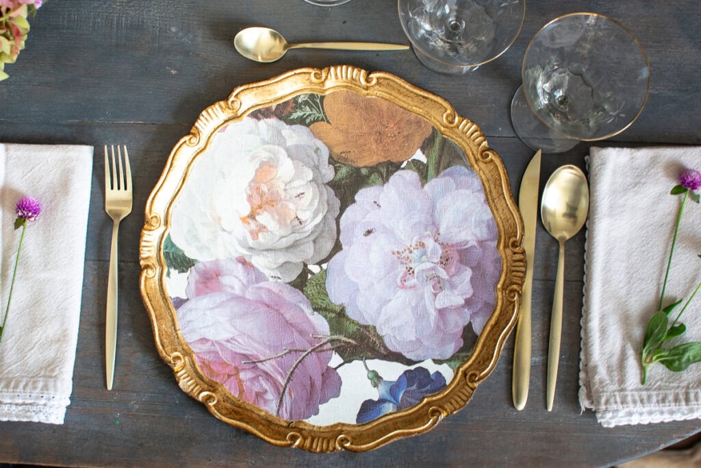 Floral charger plates with tarnished gold edges. Floral pattern is shades of pink and cream.