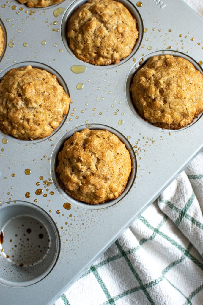 Overhead view of freshly baked oatmeal muffins still in the muffin pan.