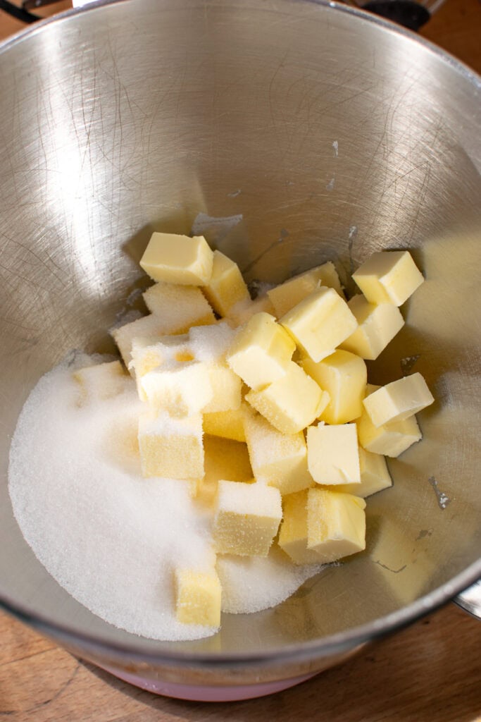 Cubed butter and granulated sugar in bowl of a stand mixer to make sweet pastry