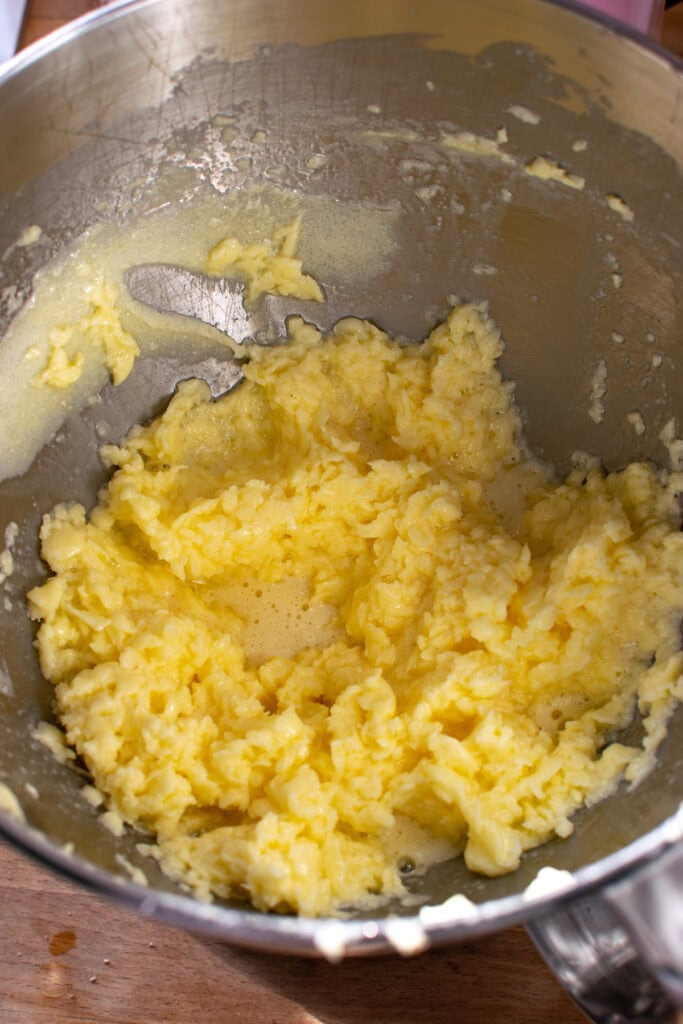 Eggs mixed into creamed butter and sugar in a stand mixer.