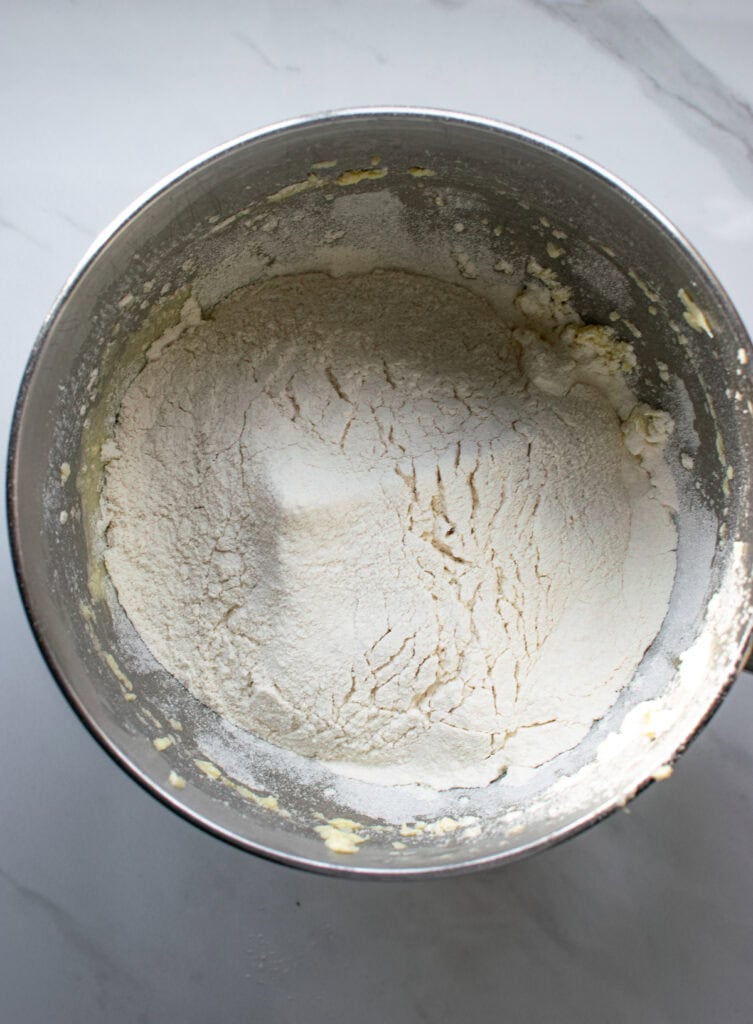 Overhead view of flour in a mixing bowl ready to be mixed into the creamed butter, sugar and eggs.