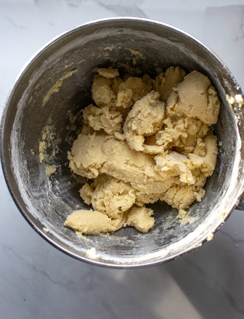 Sweet pastry dough in the bowl of an electric mixer after just being mixed.