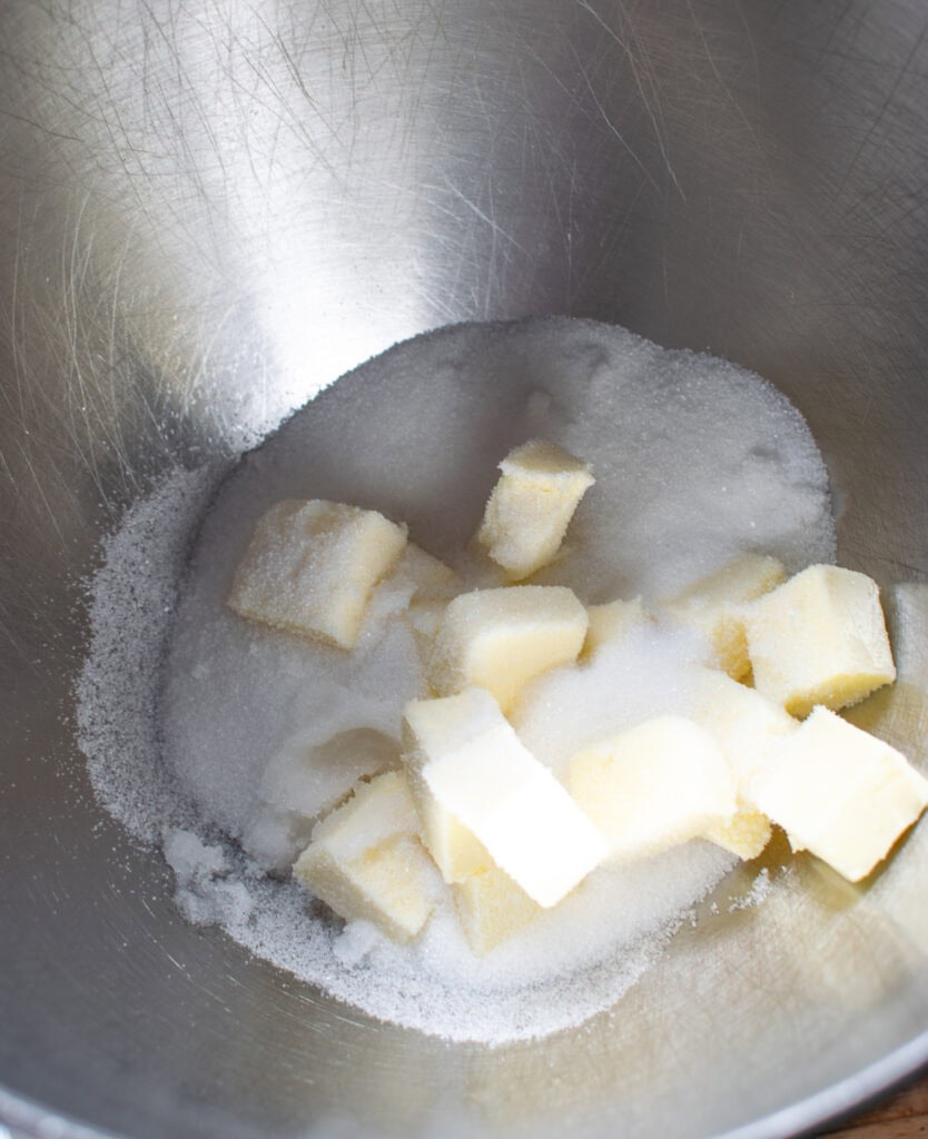 Sugar, butter and almond extract in the bowl of a stand mixer to make Cherry Bakewell tarts recipe.