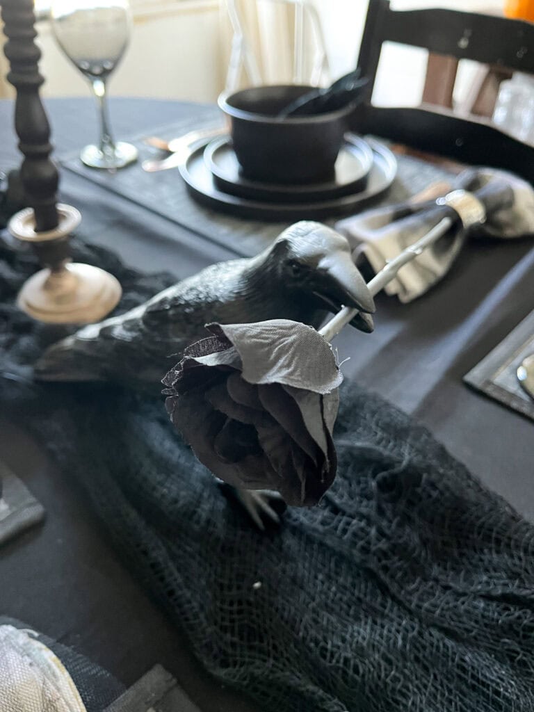 A black crow themed dinner table for a halloween party.