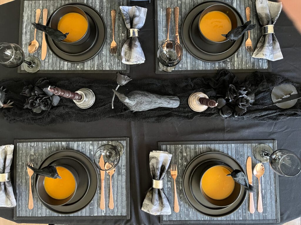 An overhead view of a table set with crow halloween decor.