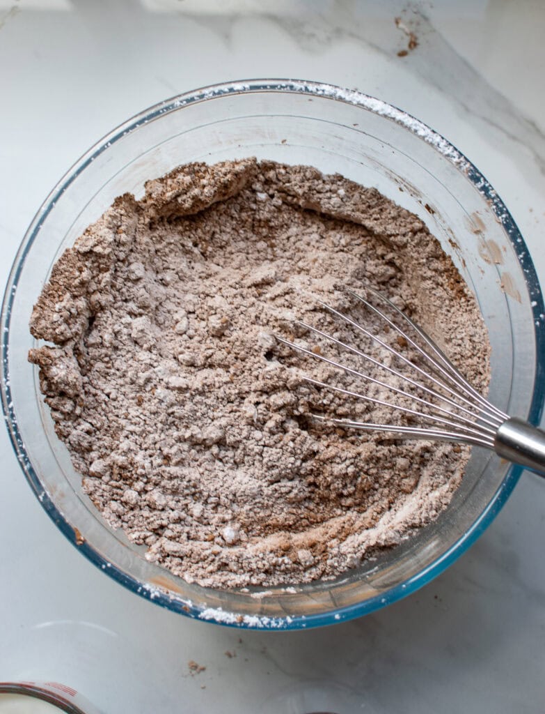 Cocoa powder and confectioners sugar whisked to blend together in a glass bowl.