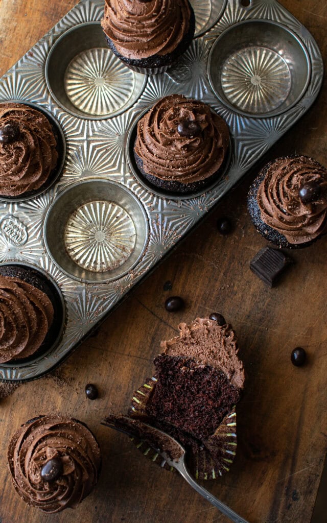 Overhead view of chocolate mocha cupcakes with one cut in half.