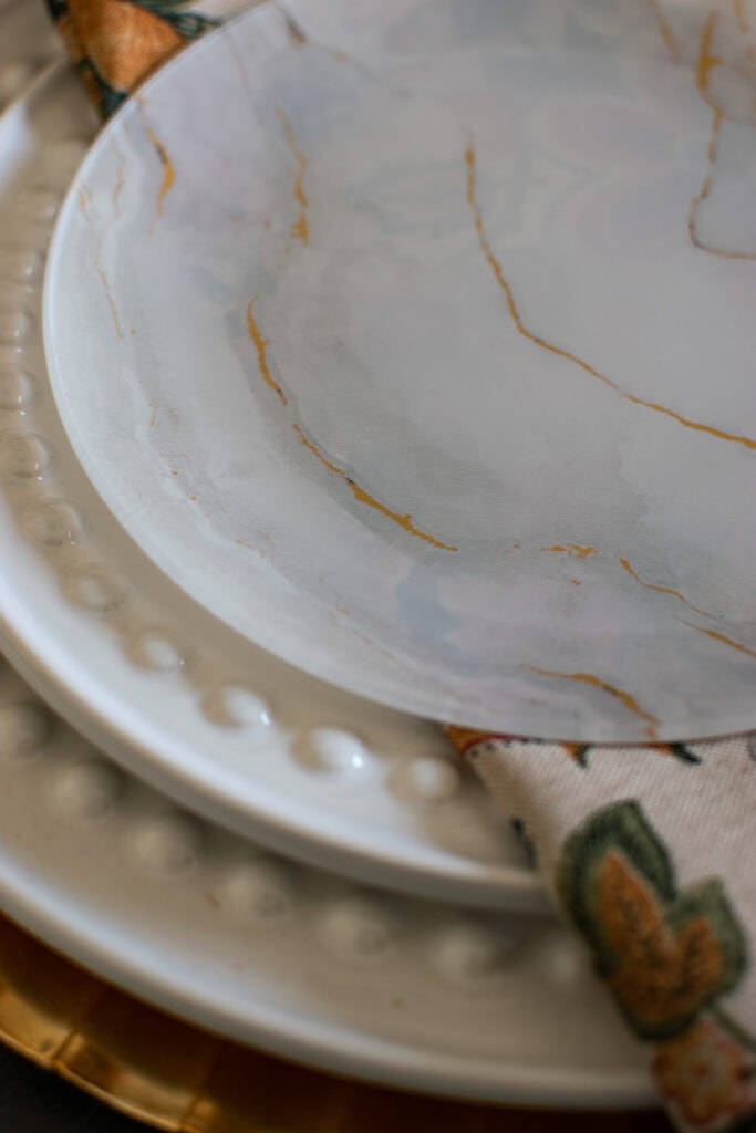 A close up of a frosted glass dessert plate with gold veining.