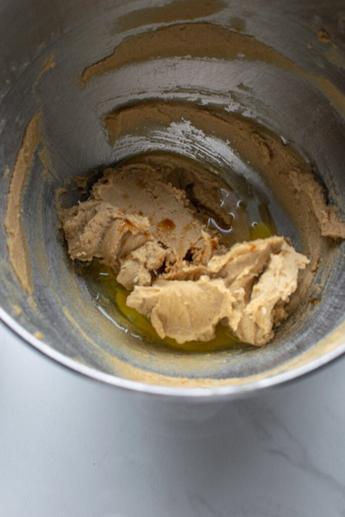 Eggs added to mixing bowl with brown sugar and butter that has been creamed together