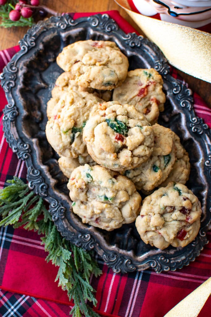 An overhead view of cherry cookies on a tarnished silver platter.