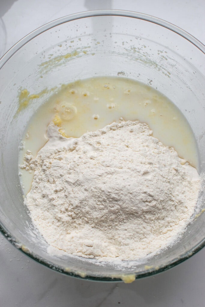 We and dry ingredients for muffins being combined in a glass mixing bowl.