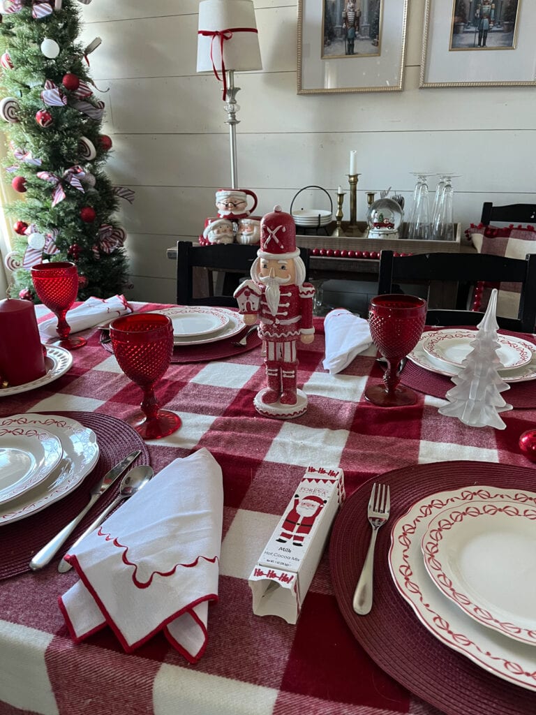 Red and white Christmas decor in a dining room including a table set in all red and white dishes and linens.