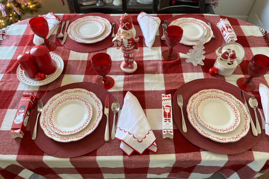 An overhead view of a dinner table dressed in red and white for Christmas.