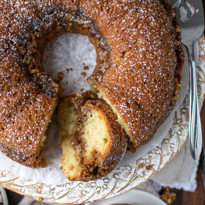 An overhead view of a cinnamon coffee cake with a slice cut out and laying on its' side.